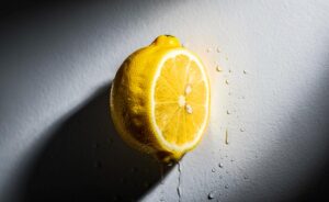 Illustration von halbierten Zitronen, die mit der Schnittfläche nach außen an einer weißen Wand befestigt sind.